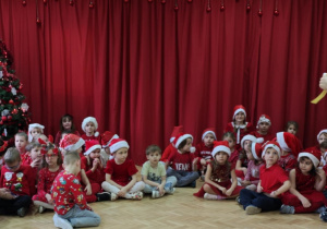 Dzieci ze starszych grup słuchają prowadzącej uroczystość.