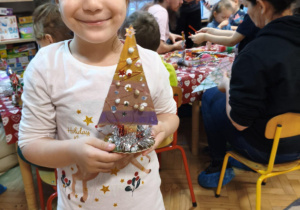 Dziecko prezentuje gotową choinkę