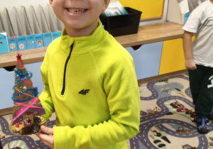 Dziecko prezentuje gotową choinkę