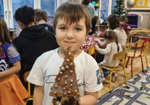 Dziecko prezentuje gotową choinkę