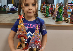 Dziecko prezentuje gotowe choinki