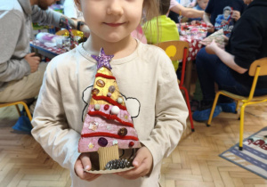 Dziecko prezentuje gotową choinkę