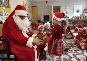 Mikołaj podczas wręczania prezentu dziecku