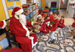 Mikołaj wręcza prezent dziecku