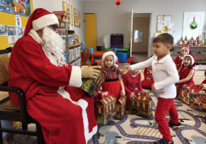 Mikołaj podczas wręczania prezentu