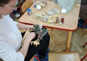 Rodzice i dzieci wykonują ozdoby świąteczne.