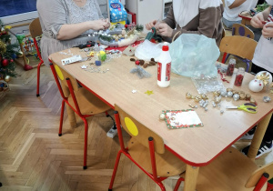 Rodzice i dzieci wykonują ozdoby świąteczne.