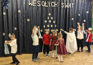 Dzieci, jako śnieżynki, tańczą do muzyki klasycznej.