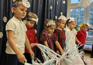 Dzieci, jako śnieżynki, tańczą do muzyki klasycznej.