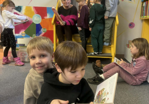 Grupa dzieci ogląda książkę.