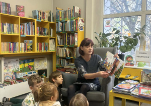 Pani bibliotekarka czyta dzieciom książkę.