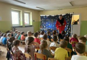 Pan magik prezentuje sztuczkę.