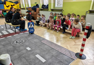 Dzieci słuchają przedstawicielek Straży Miejskiej.