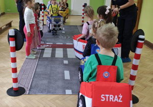Dzieci wcielają się w rolę pojazdów i pieszych poruszających się w ruchu drogowym.