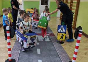Dzieci wcielają się w rolę pojazdów i pieszych poruszających się w ruchu drogowym.