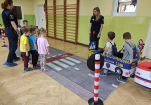 Dzieci wcielają się w rolę pojazdów i pieszych poruszających się w ruchu drogowym.