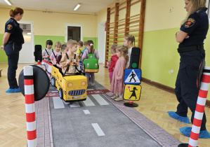 Dzieci wcielają się w rolę pojazdów i pieszych poruszających się w ruchu drogowym.