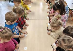 Dzieci na polecenie nauczyciela rysują na śnieżynce, zaczynając od kropki, tylko 1 kreskę i przesuwają się na miejsce sąsiada, by tam ponownie wykonać to samo zadanie.