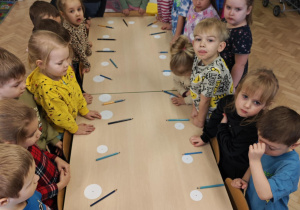 Dzieci słuchają wyjaśnień nauczyciela dotyczących wspólnej zabawy.