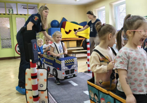 Dzieci uczestniczą w zabawie dotyczącej ruchu drogowego.