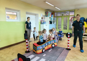 Dzieci uczestniczą w zabawie dotyczącej ruchu drogowego.