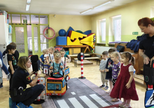 Dzieci uczestniczą w zabawie dotyczącej ruchu drogowego.