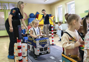Dzieci uczestniczą w zabawie dotyczącej ruchu drogowego.
