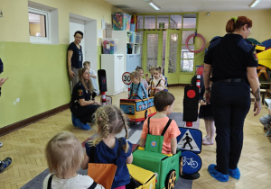 Dzieci uczestniczą w zabawie dotyczącej ruchu drogowego.