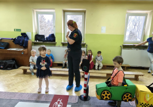 Dzieci uczestniczą w zabawie dotyczącej ruchu drogowego.