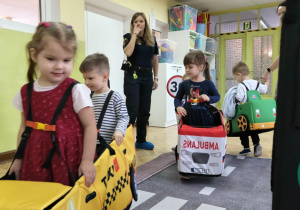 Dzieci uczestniczą w zabawie dotyczącej ruchu drogowego.