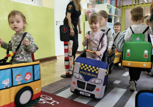 Dzieci uczestniczą w zabawie dotyczącej ruchu drogowego.
