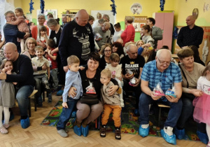 Dzieci wręczają prezenty swoim dziadkom.