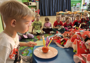 5 urodziny Marka - chłopiec zdmuchuje urodzinowe świeczki.