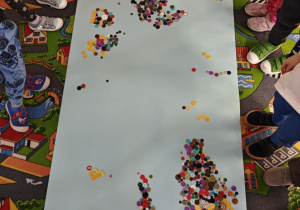 Dzieci tworzą wzory z guzików.