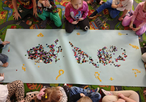 Dzieci tworzą zbiory żółtych guzików.