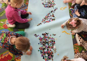 Dzieci tworzą zbiory żółtych guzików.