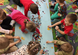 Dzieci tworzą zbiory żółtych guzików.