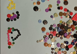 Dzieci tworzą wzory z guzików.
