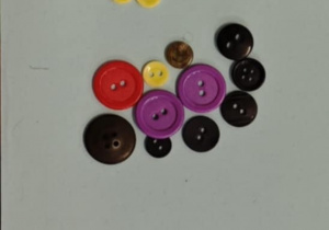 Dzieci tworzą wzory z guzików.