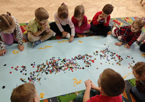 Dzieci tworzą zbiory żółtych guzików.