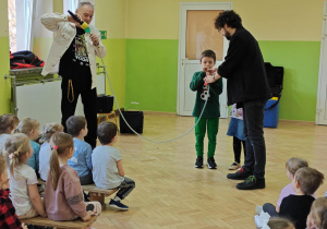 Dzieci próbują wydobyć dźwięki z "nowoczesnej" trąbki.