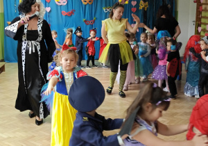 Dzieci z paniami tworzą karnawałowy pociąg.