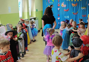 Dzieci z paniami tworzą karnawałowy pociąg.