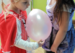 Dzieci tańczą w parach z balonami.