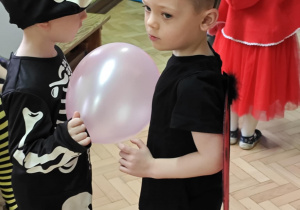 Dzieci tańczą w parach z balonami.