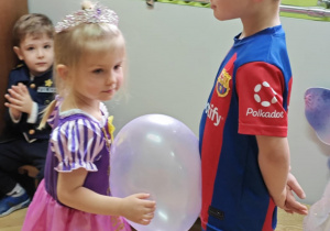 Dzieci tańczą w parach z balonami.