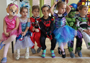 Dzieci z grupy niebieskiej siedzą na ławce i odpoczywają .