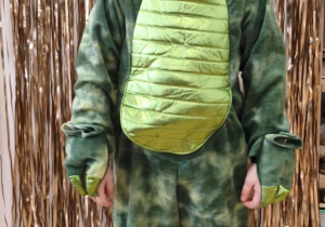 Chłopiec w stroju dinozaura.