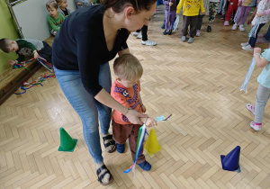 Dzieci przenoszą piórka na łyżce.