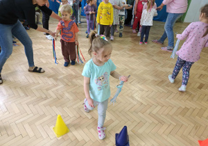 Dzieci przenoszą piórka na łyżce.